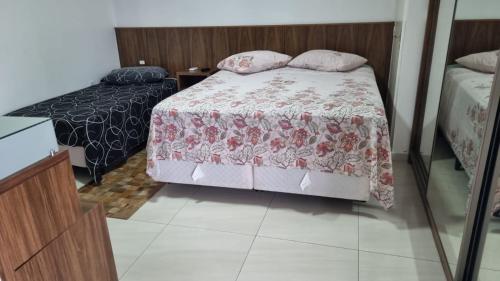 a bedroom with a bed and a mirror at Refúgio Paradisíaco 3 in Piçarras