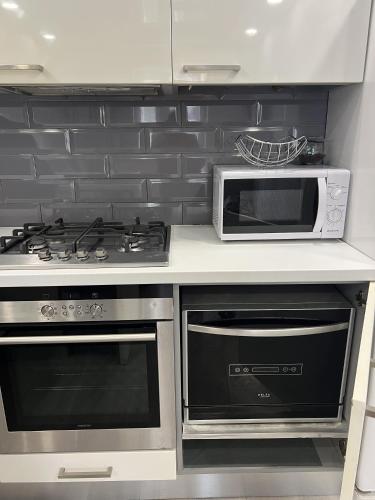 a kitchen with a microwave and a stove at Сучасна та простора квартира в гарному районі міста біля парку in Irpin'