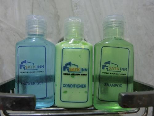 three bottles of detergent sitting on a shelf at SATK INN Jaffna, Kokkuvil in Kokkuvil East