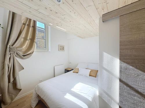 a bedroom with a white bed and a window at Fleurie - Anse Centre - Chambre et Salle de bain WC privée - Cuisine partagée in Anse