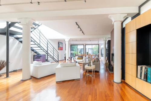 Il comprend un salon doté d'un mobilier blanc et d'un escalier. dans l'établissement Large fully renovated 250m house, à Nantes