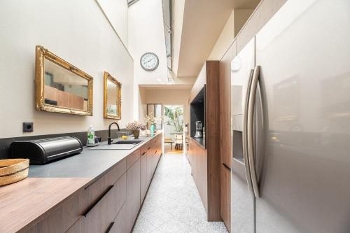 une cuisine avec un évier et un réfrigérateur dans l'établissement Large fully renovated 250m house, à Nantes