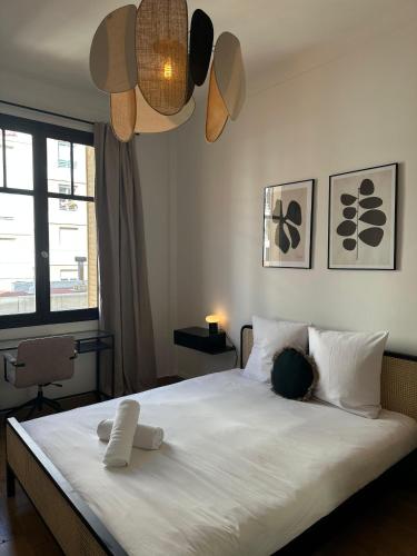 une chambre avec un lit avec des draps blancs et une fenêtre dans l'établissement Auber - T3 Refait à neuf centre de Nice, à Nice