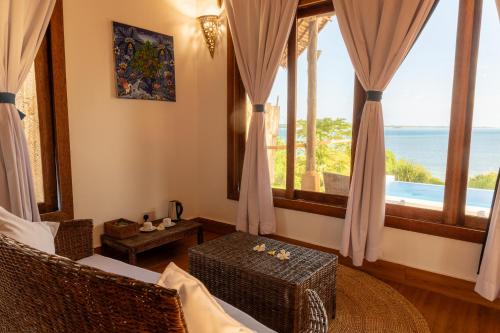 a living room with a view of the ocean at Pole Pole Bungalows in Utende