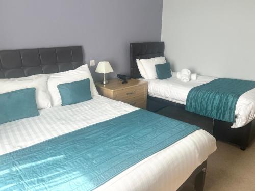 a bedroom with two beds with blue and white at Exeter Court Hotel in Exeter