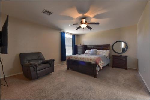 a bedroom with a ceiling fan and a bed and a chair at El Paso Comfy Home in El Paso