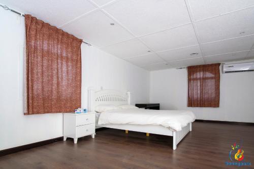 a bedroom with a white bed and a window at Cozy Studio Chalets in Madīnat an Nahḑah