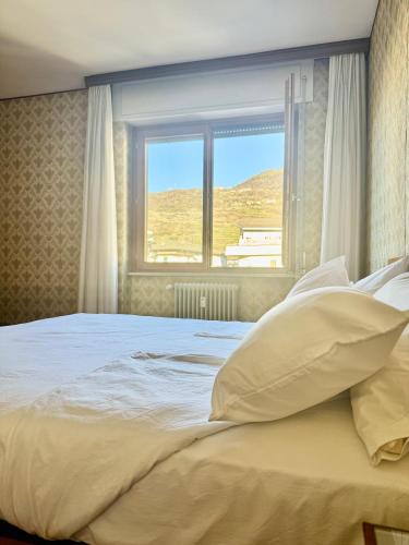 a bedroom with a large bed with a window at Nido tra monti in Sondrio