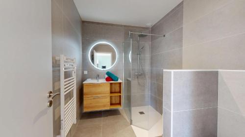 Un baño con ducha, lavabo y espejo. en La Petite Vague, en Saint Gilles Croix de vie