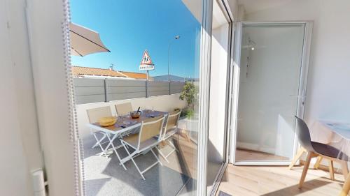 une salle à manger avec une table, des chaises et un miroir dans l'établissement La Petite Vague, à Saint-Gilles-Croix-de-Vie