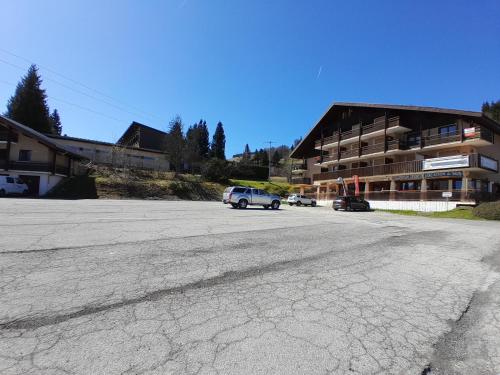 ein leerer Parkplatz vor einem Gebäude in der Unterkunft Y Hôtes- Ambiance Montagne T2 Station Hirmentaz in Bellevaux