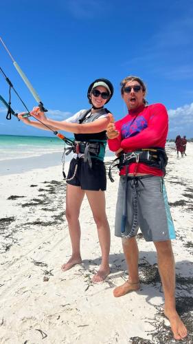 two people standing on a beach holding a kite at B4 BOUTIQUE in Paje