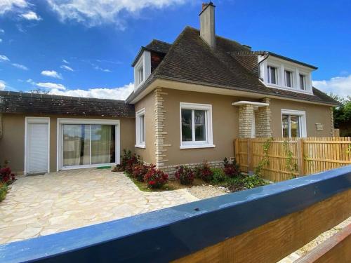 une maison avec une clôture devant dans l'établissement Horizon Bois by Melrose, à Asnelles