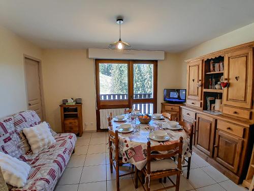 ein Wohnzimmer mit Tisch und Couch in der Unterkunft Y Hôtes- Ambiance Montagne T2 Station Hirmentaz in Bellevaux