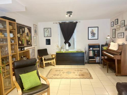 - un salon avec un piano et une chaise dans l'établissement Villa Familiale Soleil et détente, à Salignac