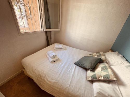 - un petit lit avec 2 serviettes et une balance dans l'établissement Sete T2 avec piscine, parking, proche des plages, à Sète