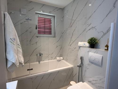 a bathroom with a shower and a tub and a sink at Apartments Plazs 41 in Sukošan