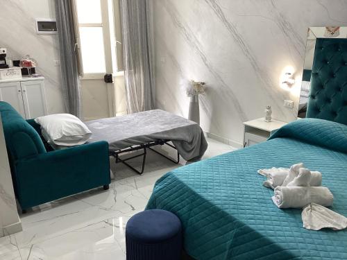 a bedroom with a blue bed and a chair at La Vecchia Rosa in Catania