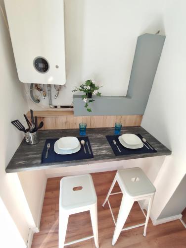 a kitchen counter with two stools and a mirror at Hostel Temza in Zagreb