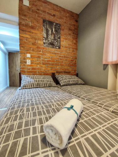 a large bed in a room with a brick wall at Hostel Temza in Zagreb