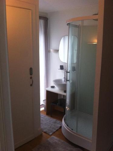 een badkamer met een glazen douche en een wastafel bij Résidence18 in Brussel