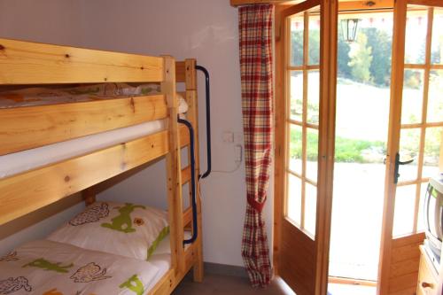 Zimmer mit Etagenbett und 2 Etagenbetten neben einer Tür in der Unterkunft Chalet Charming in Grächen
