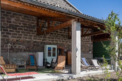 a group of chairs sitting outside of a brick building at C'est Chouette le gîte ! in Saint-Jodard