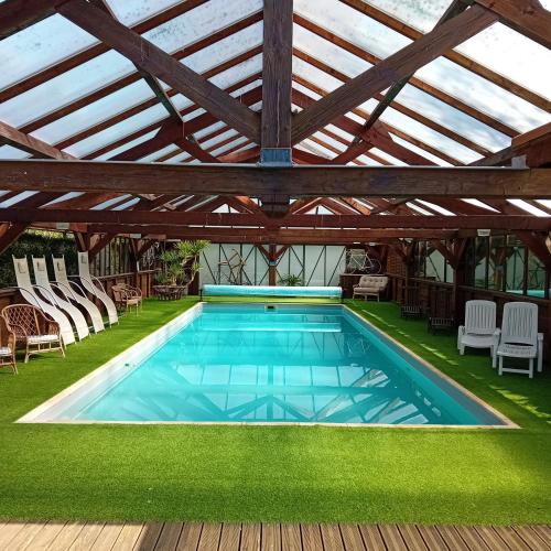- une piscine sous une pergola en bois avec une piscine dans l'établissement Peaceful Retreat, à Bessines-sur-Gartempe