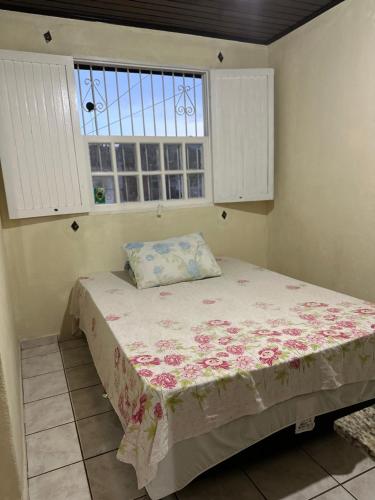 a bed in a room with a window at Recanto aconchego in Santa Cruz