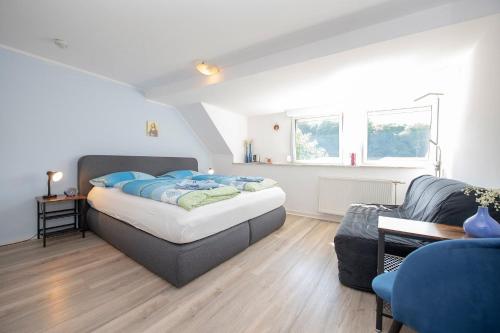 a bedroom with a bed and a couch at Gästehaus Mona Lisa in Neef