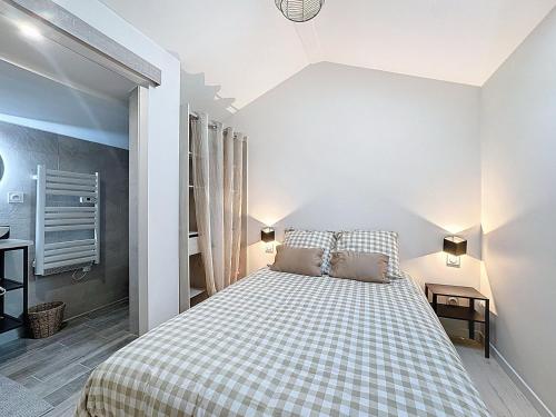 une chambre avec un lit avec une couverture à carreaux dans l'établissement Juliana - Anse Centre - Chambre et Salle de bain WC privée - Cuisine partagée, à Anse