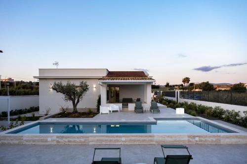 a villa with a swimming pool and a house at Villa Kora Suites&Pool in San Leone