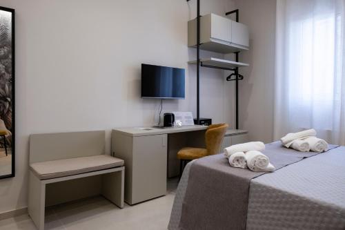 a room with two beds and a desk with a computer at Villa Kora Suites&Pool in San Leone