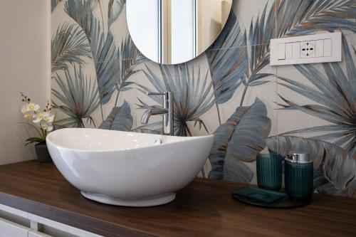 a bathroom with a white sink and a mirror at Villa Kora Suites&Pool in San Leone