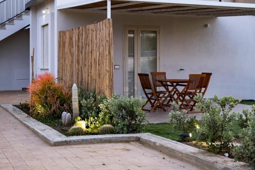 a patio with chairs and a table in a garden at Villa Kora Suites&Pool in San Leone