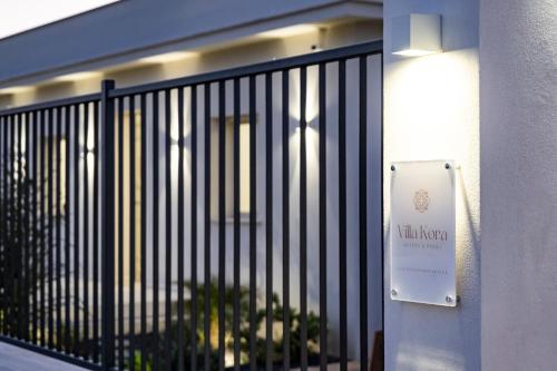 a sign on a fence in front of a building at Villa Kora Suites&Pool in San Leone
