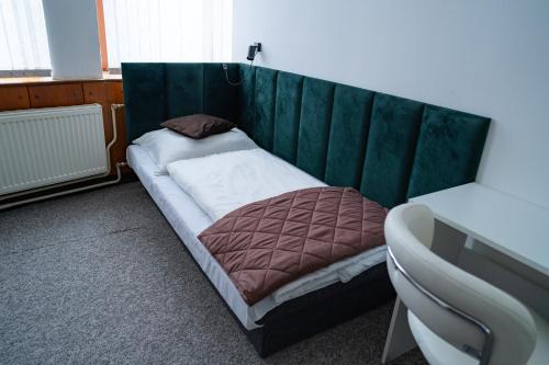 a small bed with a green headboard in a room at Penzión Oliver Humenné in Humenné