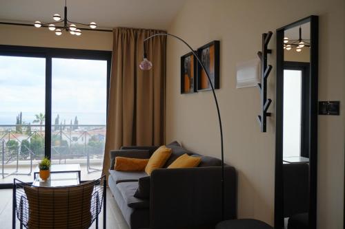 a living room with a couch and a large window at Wonderful view from the beautiful apartments in Paphos City