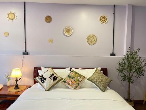 Un dormitorio con una cama con sábanas y almohadas blancas. en The Memory Hostel, en Trat