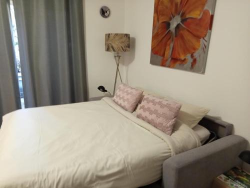 a bedroom with a bed with pink pillows on it at Fully equipped studio in Saint-Germain-de-Joux