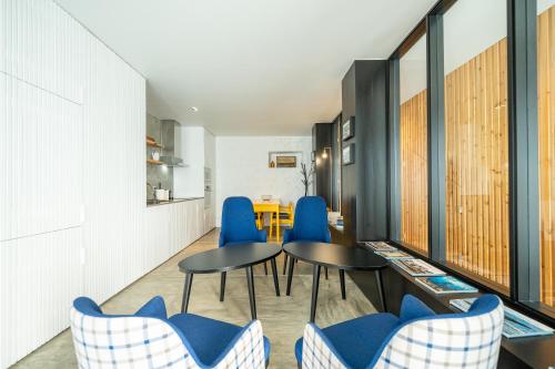 a dining room with blue chairs and a table at Engenho Hostel in Lajes do Pico