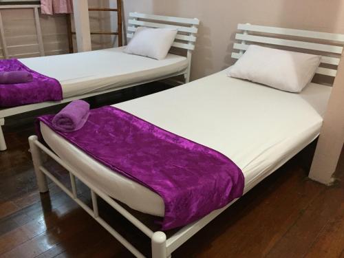 Honey Place Guesthouse,special rate for long stay في بانكوك: سريرين في غرفة مع بطانيات أرجوانية
