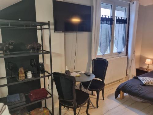 a living room with a table and chairs and a bed at La Maison in Mirebeau-sur-Bèze