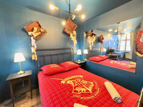 - une chambre avec 2 lits dotés de draps rouges et d'une poudrière dans l'établissement Le Studio Des Sorciers ! Hyper Centre Arras, à Arras