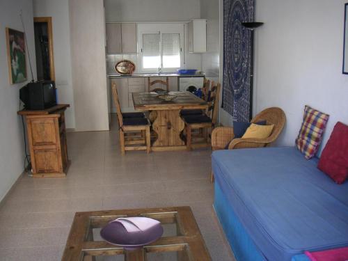 a living room with a blue couch and a table at Casa Barbados in Agua Amarga