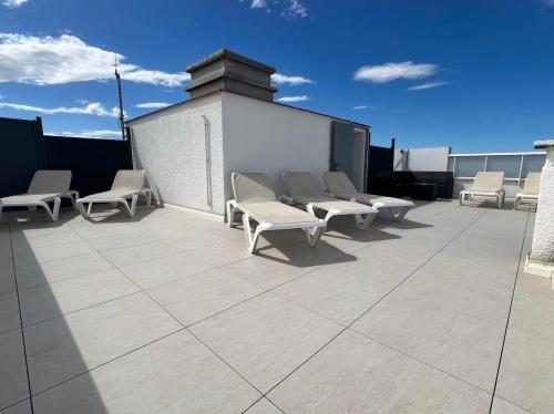 un groupe de chaises assises sur un toit dans l'établissement Le Canetois, à Canet