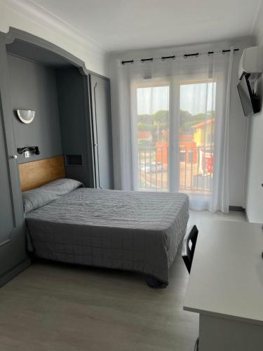 une chambre avec un lit et une grande fenêtre dans l'établissement Le Canetois, à Canet