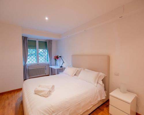 a bedroom with a white bed and a window at San Paolo Apartment in Pisa