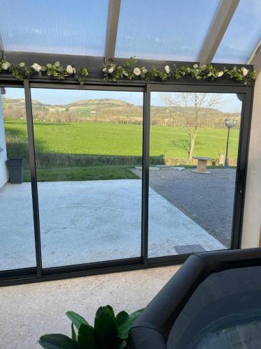 a sliding glass door with a view of a yard at les gîtes de la cuesta in Henneveux