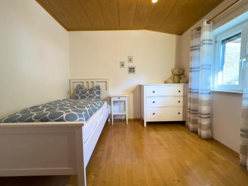 a bedroom with a bed and a dresser and a window at Apartment Rosengarten - Rosenheim Apartments in Tires